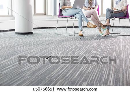 Stock Image - Low section of businesswomen working in creative office. Fotosearch