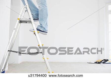 Stock Image - Low section of man on ladder. Fotosearch