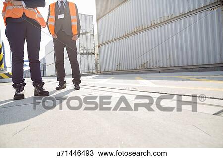 Low section of workers standing in shipping yard View Large Photo Image Stock Image - Low section of workers standing in shipping yard. Fotosearch