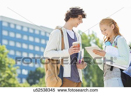 Male and female students using digital tablet at college campus View Large Photo Image Stock Photography - Male and female students using digital tablet at college campus. Fotosearch