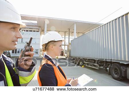 Male and female workers working in shipping yard View Large Photo Image Stock Photo - Male and female workers working in shipping yard. Fotosearch