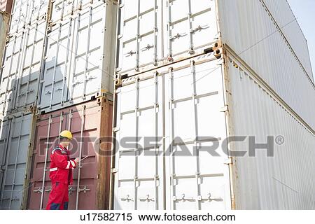 Male worker inspecting cargo containers while writing on clipboard in shipping yard View Large Photo Image Stock Photography - Male worker inspecting cargo containers while writing on clipboard in shipping yard. Fotosearch