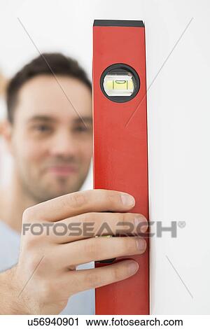Man using spirit level in new house View Large Photo Image Stock Image - Man using spirit level in new house. Fotosearch