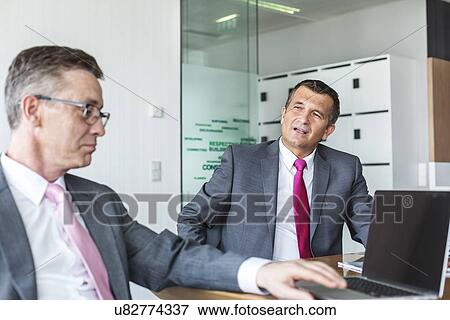 Mature businessmen discussing in office View Large Photo Image Stock Photo - Mature businessmen discussing in office. Fotosearch