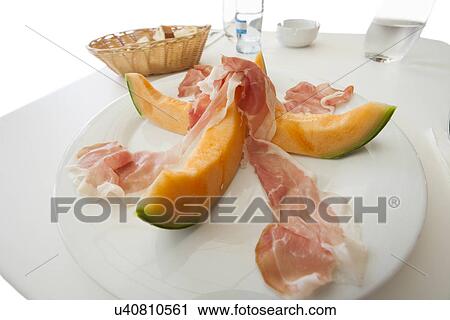 Melon slices with meat served on plate View Large Photo Image Stock Image - Melon slices with meat served on plate. Fotosearch
