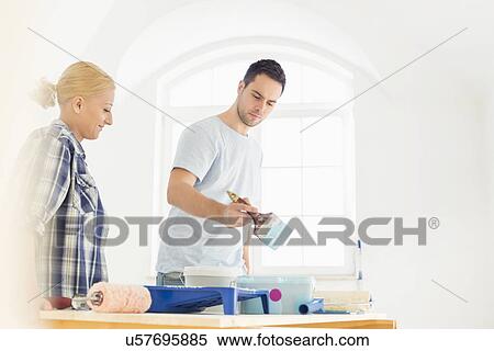 Mid-adult couple painting in new house View Large Photo Image Stock Photography - Mid-adult couple painting in new house. Fotosearch