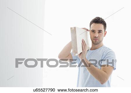 Mid-adult man carrying lumber on shoulder View Large Photo Image Stock Image - Mid-adult man carrying lumber on shoulder. Fotosearch