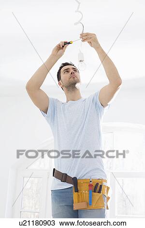 Mid-adult man fixing light bulb wiring in new house View Large Photo Image Stock Image - Mid-adult man fixing light bulb wiring in new house. Fotosearch