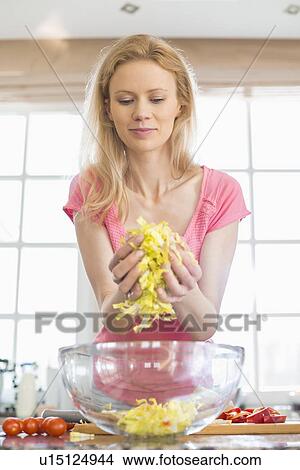 Mid adult woman preparing vegetable salad in kitchen View Large Photo Image Picture - Mid adult woman preparing vegetable salad in kitchen. Fotosearch