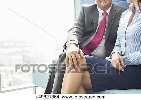 Midsection of businessman flirting with female colleague in office View Large Photo Image Picture - Midsection of businessman flirting with female colleague in office. Fotosearch