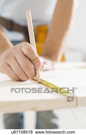 Midsection of carpenter marking table with measure tape View Large Photo Image Stock Photo - Midsection of carpenter marking table with measure tape. Fotosearch