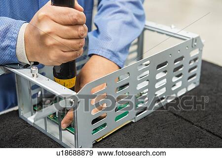 Midsection of male engineer repairing computer part in electronics industry View Large Photo Image Stock Photo - Midsection of male engineer repairing computer part in electronics industry. Fotosearch