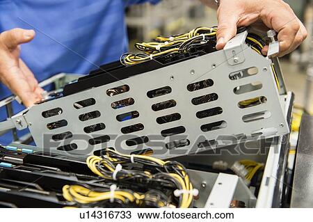 Stock Image - Midsection of male technician examining video card in computer manufacturing industry. Fotosearch