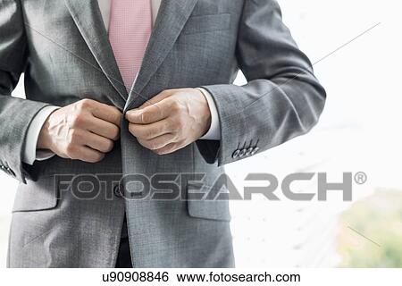Midsection of mature businessman buttoning his blazer View Large Photo Image Stock Photograph - Midsection of mature businessman buttoning his blazer. Fotosearch