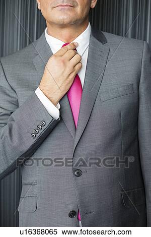 Midsection of mature businessman adjusting necktie View Large Photo Image Stock Photography - Midsection of mature businessman adjusting necktie. Fotosearch