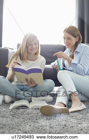 Mother assisting daughter in homework at home View Large Photo Image Stock Image - Mother assisting daughter in homework at home. Fotosearch