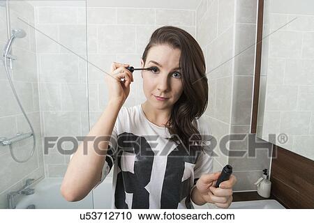 Portrait of beautiful woman applying mascara in bathroom View Large Photo Image Stock Image - Portrait of beautiful woman applying mascara in bathroom. Fotosearch