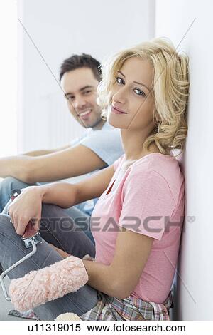 Portrait of beautiful woman holding paint roller with man in background View Large Photo Image Stock Photography - Portrait of beautiful woman holding paint roller with man in background. Fotosearch