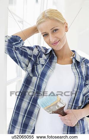 Portrait of beautiful woman holding paintbrush in new house View Large Photo Image Stock Photography - Portrait of beautiful woman holding paintbrush in new house. Fotosearch
