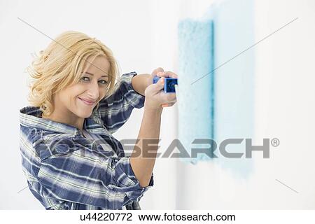 Portrait of beautiful woman painting wall with paint roller View Large Photo Image Stock Image - Portrait of beautiful woman painting wall with paint roller. Fotosearch