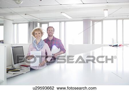 Portrait of confident business people standing in office View Large Photo Image Stock Image - Portrait of confident business people standing in office. Fotosearch