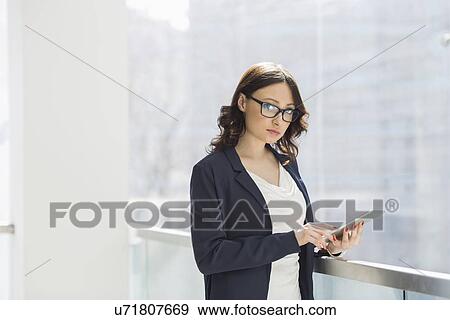 Stock Photo - Portrait of confident businesswoman using tablet PC in office. Fotosearch