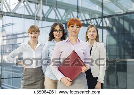 Stock Image - Portrait of confident businesswomen standing together in office. Fotosearch