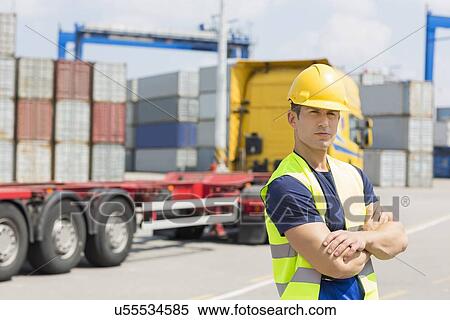 Portrait of confident mid adult man in shipping yard View Large Photo Image Stock Photography - Portrait of confident mid adult man in shipping yard. Fotosearch