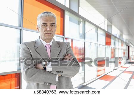 Stock Image - Portrait of confident middle aged businessman at railroad station. Fotosearch