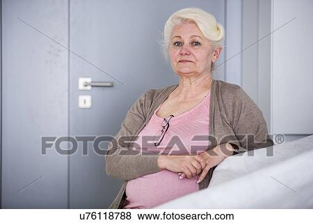 Portrait of confident senior woman sitting in house View Large Photo Image Stock Photo - Portrait of confident senior woman sitting in house. Fotosearch