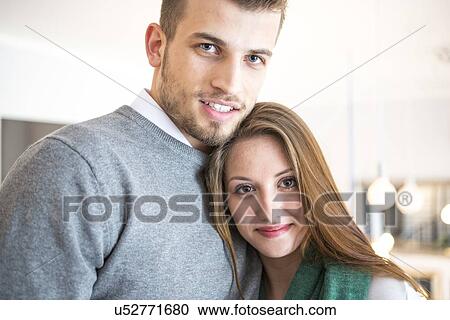 Stock Image - Portrait of confident young couple at cafe. Fotosearch