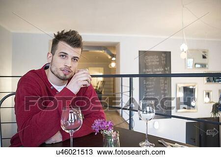Portrait of confident young man drinking water from glass in cafe View Large Photo Image Stock Image - Portrait of confident young man drinking water from glass in cafe. Fotosearch