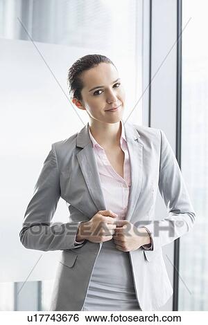 Portrait of confident young businesswoman in office View Large Photo Image Stock Photograph - Portrait of confident young businesswoman in office. Fotosearch