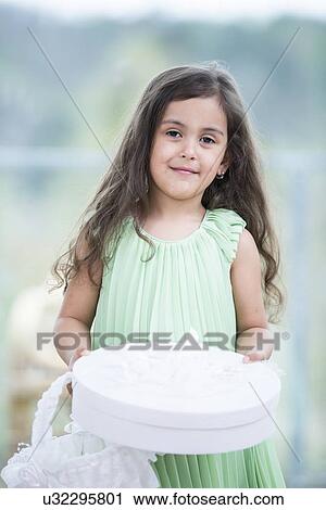 Portrait of cute girl holding gift box and basket at home View Large Photo Image Stock Image - Portrait of cute girl holding gift box and basket at home. Fotosearch