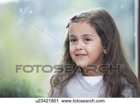 Portrait of cute little girl against glass window at home View Large Photo Image Stock Image - Portrait of cute little girl against glass window at home. Fotosearch