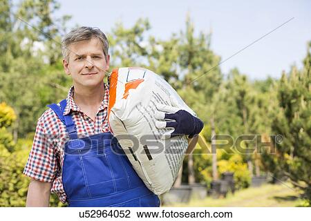 Portrait of gardener carrying sack in plant nursery View Large Photo Image Stock Image - Portrait of gardener carrying sack in plant nursery. Fotosearch