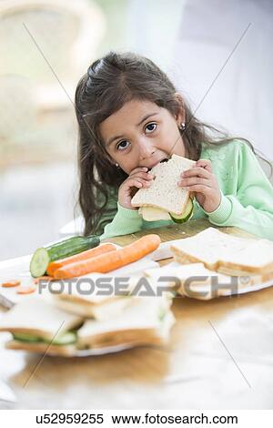 Portrait of girl eating sandwich at home View Large Photo Image Stock Photography - Portrait of girl eating sandwich at home. Fotosearch