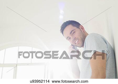 Picture - Portrait of handsome man on call at home. Fotosearch