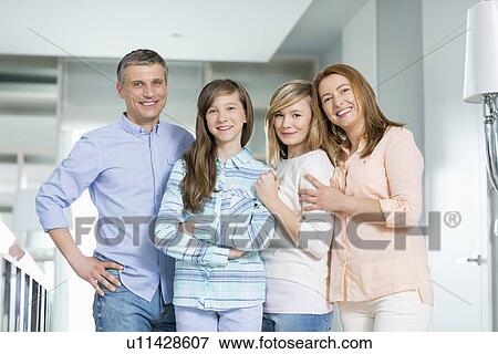Stock Photo - Portrait of happy family with children standing together at home. Fotosearch