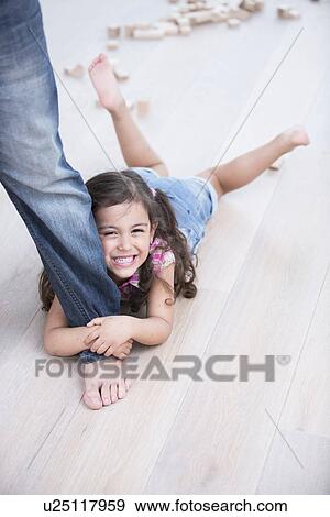 Portrait of happy girl being dragged by father on hardwood floor View Large Photo Image Stock Photo - Portrait of happy girl being dragged by father on hardwood floor. Fotosearch