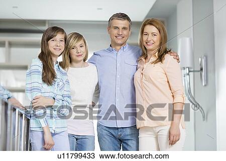 Portrait of happy parents with daughters standing together at home View Large Photo Image Stock Image - Portrait of happy parents with daughters standing together at home. Fotosearch