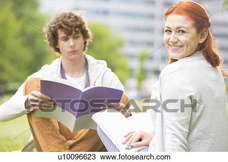 Portrait of happy young woman with male friend studying at college campus View Large Photo Image Stock Image - Portrait of happy young woman with male friend studying at college campus. Fotosearch
