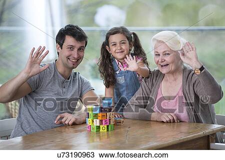 Portrait of senior woman with son and granddaughter waving hands at table View Large Photo Image Stock Image - Portrait of senior woman with son and granddaughter waving hands at table. Fotosearch