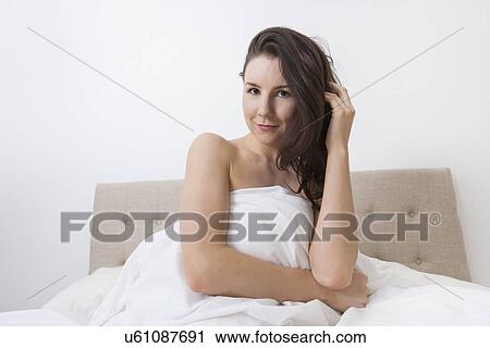 Portrait of sensuous woman covered with bedsheet in bed View Large Photo Image Stock Image - Portrait of sensuous woman covered with bedsheet in bed. Fotosearch
