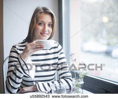 Portrait of smiling woman having coffee at cafe table View Large Photo Image Stock Image - Portrait of smiling woman having coffee at cafe table. Fotosearch