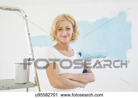 Portrait of woman with paint roller in new house View Large Photo Image Stock Image - Portrait of woman with paint roller in new house. Fotosearch