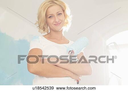 Portrait of woman with paint roller in new house View Large Photo Image Stock Photo - Portrait of woman with paint roller in new house. Fotosearch