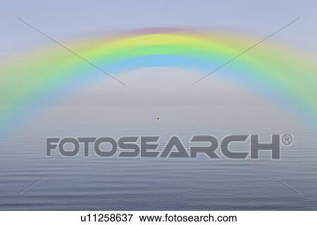 Rainbow over calm lake View Large Photo Image Stock Photo - Rainbow over calm lake. Fotosearch