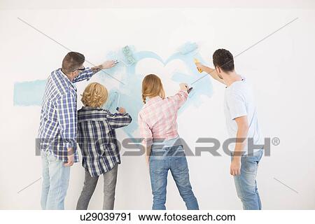 Rear view of couples painting wall in new home View Large Photo Image Stock Image - Rear view of couples painting wall in new home. Fotosearch