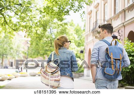 Rear view of young college friends talking while walking in campus View Large Photo Image Stock Photography - Rear view of young college friends talking while walking in campus. Fotosearch